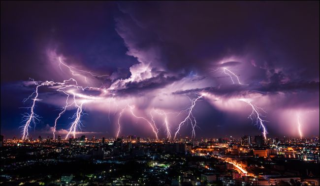 Tempesta di fulmini sulla città alla luce viola