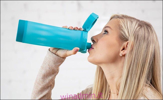 Una donna che beve da una bottiglia d'acqua intelligente.