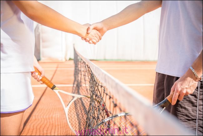 Due giocatori si stringono la mano a un campo da tennis