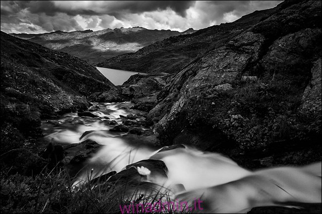 Una foto in bianco e nero di un ruscello in montagna dopo la pioggia.